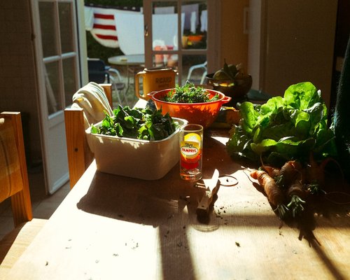 fresh organic fruits and green vegetables on a bright kitchen table